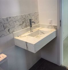 a bathroom sink sitting under a mirror next to a wall mounted toothbrush dispenser