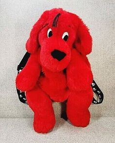 a red stuffed dog sitting on top of a white couch