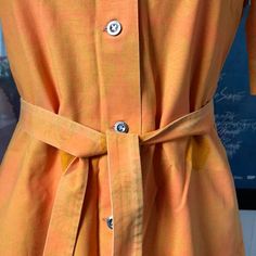 This is a beautiful and rare shirt dress / art dress from Finnish company Marimekko. Made in the 1969s (as the tag shows). 100% cotton. Marked as a Size 38. Fits a normal size Small, could also fit Medium. Good but not perfect condition, crispy cotton. One button (furthest down) is missing. A fixed scratch down on the front, see last pic. Sold as it is. Comes with a matching belt Orange with another Orange and Green in the pattern. Measurements, let me know if you need them. Yellow Button-up Cotton Dress, Yellow Cotton Button-up Dress, Summer Cotton Dress With Spread Collar, Orange Fitted Shirt Dress For Spring, Spring Orange Fitted Shirt Dress, Fitted Cotton Shirt Dress For Summer, Cotton Dress With Buttons And Spread Collar, Vintage Cotton Collared Shirt Dress, Vintage Cotton Shirt Dress For Daywear