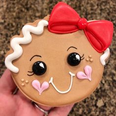 a close up of a person holding a decorated cookie