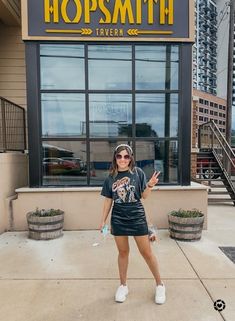 Nashville Black Skirt Outfit, Tshirt Outfit With Sneakers, Black Leather Skirt With Tshirt Outfit, Leather Skirt And Band Tee Outfit, Leather Skirt Tennis Shoes, Black Skirt With Tennis Shoes, T Shirt And Skirt Outfit Concert, Leather Shorts Graphic Tee Outfit, Skirt With Sneakers Plus Size