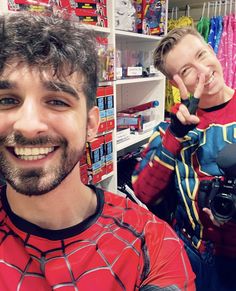 two men in spider - man costumes are taking a selfie with the cameraman