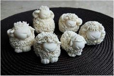 five sheep made out of white chocolate on a black plate