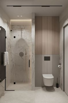 a bathroom with marble walls and flooring, including a white toilet next to a walk in shower