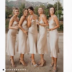 four beautiful women in dresses holding champagne flutes