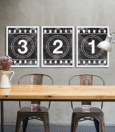 a table with four chairs and two pictures on the wall above it that say number twelve