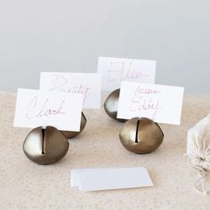 three place cards are placed on some metal balls