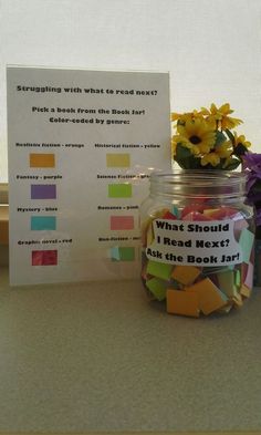 a jar filled with lots of colorful stickers next to a sign that says what should i read next?