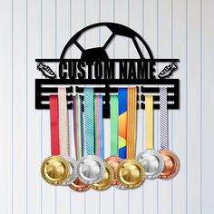 a metal sign that says custom name with medals hanging from it's center piece