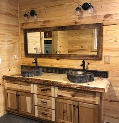 a bathroom with two sinks and wooden cabinets