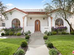 a white house with lots of windows and landscaping