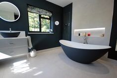 a large bathtub sitting in the middle of a bathroom next to a sink and mirror