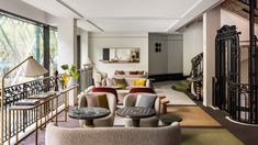 a living room filled with lots of furniture next to a window covered in glass doors