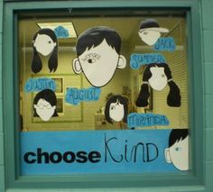 a window display with many different faces and words on the windowsill, in front of a blue brick wall