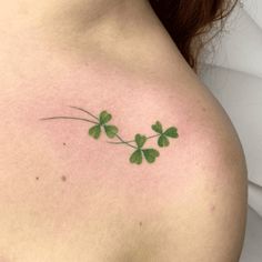 four leaf clover tattoo on the back of a woman's left shoulder and chest