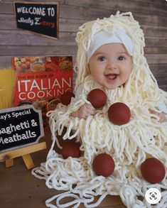 a baby dressed up in spaghetti and meatballs for halloween costume party with italian cooking sign