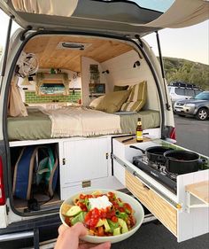 a person holding a bowl of food in the back of an rv