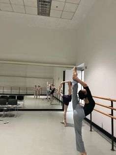 two dancers are doing an acrobatic move in the middle of a dance studio