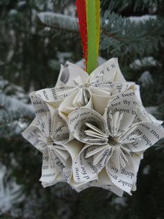 an ornament made out of book pages hanging from a tree