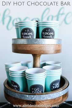 diy hot chocolate bar with ice cream cups on a cake stand and text overlay that says diy hot chocolate bar