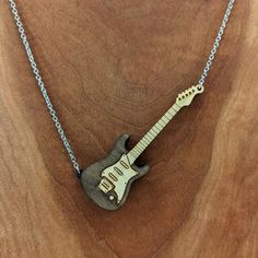 This electric guitar pendant is made from birch wood and comes on an 18” black, gold, or silver stainless steel chain. The electric guitar pendant measures approximately 3.25” tall x 1.25 wide. Engrave the back with the wording of your choice. Due to size please keep the text under 15 characters, including spaces. Free shipping for US customers. The item ordered comes in a cute gift bag. Items shown in the gift bag in the photo are for illustrative purposes. Every piece of wood is naturally diff Guitar Necklace, Guitar Pendant, Music Jewelry, Guitar Design, Engraved Necklace, Cute Gift, Black Stainless Steel, Steel Jewelry, Steel Chain