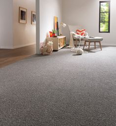 a living room with gray carpet and white furniture