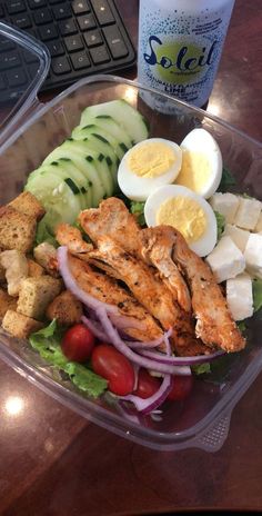 a salad with chicken, cucumber, tomatoes, lettuce and hard boiled eggs