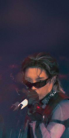 a woman wearing sunglasses and holding a microphone