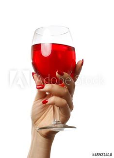 a woman's hand holding a wine glass with red liquid