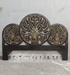 an ornately designed wooden headboard against a white wall