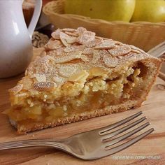 a piece of pie sitting on top of a wooden cutting board next to a fork