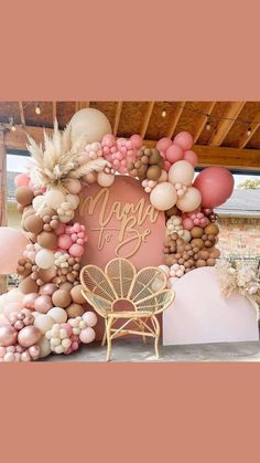 a pink and gold balloon arch with the words happy birthday on it, surrounded by balloons