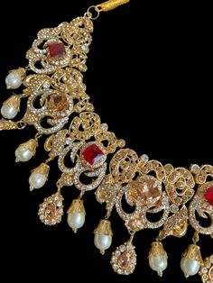 This set is the most in demand set for the upcoming wedding and festive season! The bright hues and the beautiful fit will go perfectly with any outfit and the neutral finish with gold tones can be paired with different colors for a statement look. Perfect for bridal or semi bridal wear Necklace comes with matching earrings, jhumar and tikka. Comes in 2 different colors Gold Traditional Party Wear For Eid, Gold Party Wear Sharara For Diwali, Elegant Gold Semi-stitched Anarkali Set, Elegant Red Kundan Necklace For Festive Occasions, Gold Semi-stitched Kundan Sets, Festive Gold Sharara, Elegant Tilla Traditional Wear For Party, Elegant Traditional Wear With Meenakari For Parties, Red Embellished Lehenga For Festive Occasions