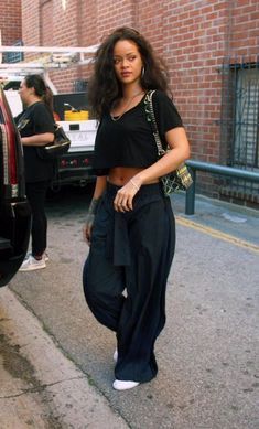 a woman walking down the street in front of a car