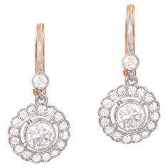 Elevate your style with the timeless elegance of these Art Deco-inspired floral diamond earrings. Meticulously handcrafted in platinum with 18k yellow gold backs, these earrings exude a luxurious and sophisticated aura. Each of the earrings showcases a mesmerizing round brilliant cut center diamond, weighing approximately 0.40 carats, capturing the light with its brilliant sparkle. Surrounding the center diamond is a halo of additional round brilliant cut diamonds, enhancing the overall radiance Vintage Diamond Earrings, Estate Diamond Jewelry, Colored Diamond Rings, Floral Halo, Platinum Earrings, Diamond Earring, Fancy Diamonds, Antique Necklace, Wedding Jewelry Earrings