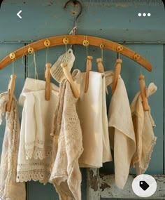 several white towels hanging from a rack on a blue wooden wall with an old door in the background