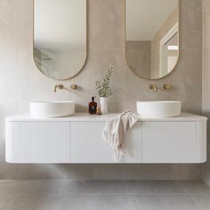 two white sinks and mirrors in a bathroom