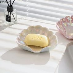 two bowls with some food in them sitting on a table next to a window sill