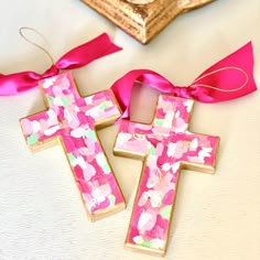 two decorated wooden crosses with pink ribbons