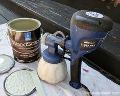 a paint can and some other items on a table next to a wood plank bench