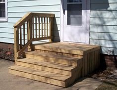 a wooden stair case next to a house