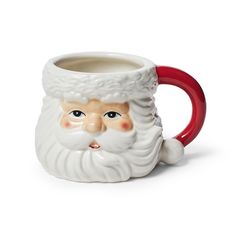 a ceramic mug with a santa face on it's side and red rimmed handle