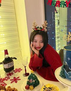 a woman sitting at a table in front of a cake and other desserts on plates