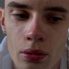 a close up of a person holding a cell phone to their face with teary eyes