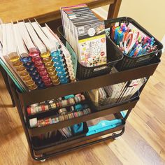 a cart filled with craft supplies on top of a hard wood floor