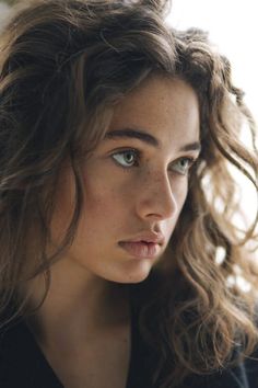 a close up of a person with long hair and blue eyes looking at the camera