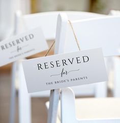 reserved for the bride's parents sign on white chairs with twine tied to them