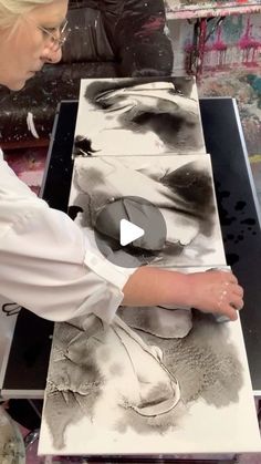 a woman is working on an art project with black and white images in the background