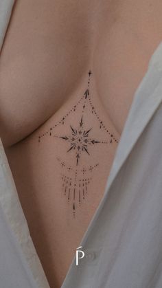 a woman's chest with a star tattoo on her left side and an arrow in the middle