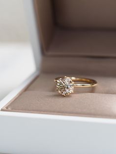 an engagement ring sits in a box